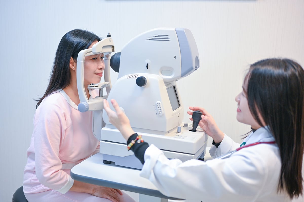 En una clínica oftalmológica de última generación, un paciente se sienta frente a una máquina de exploración oftalmológica mientras un médico realiza un examen retinal exhaustivo
